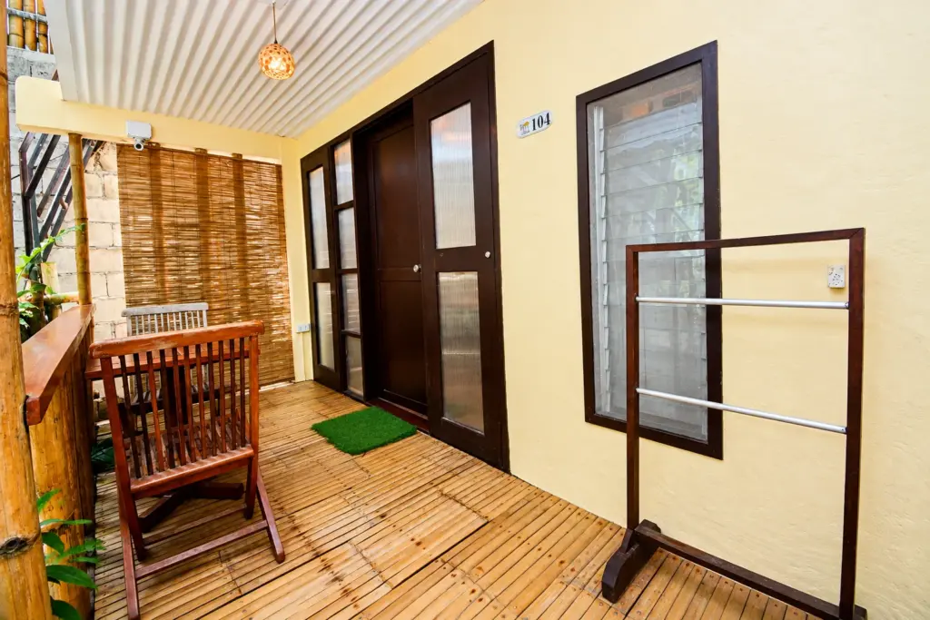 Cottage entrance deck with a wooden chair and towel rack