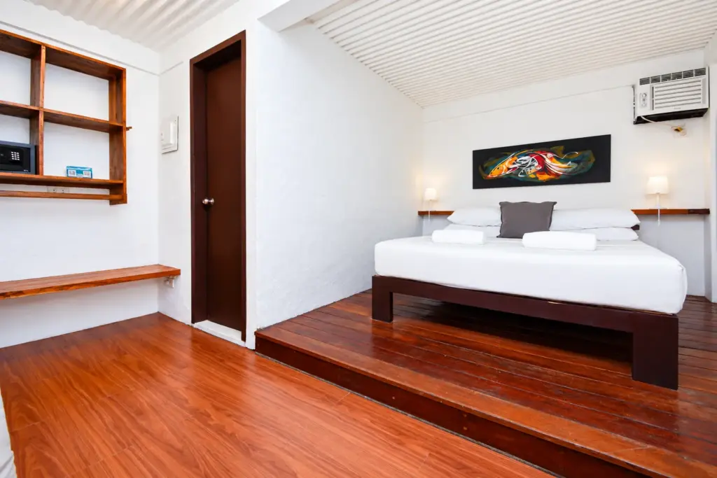 Cottage queen bed on a polished wood floor with open shelving