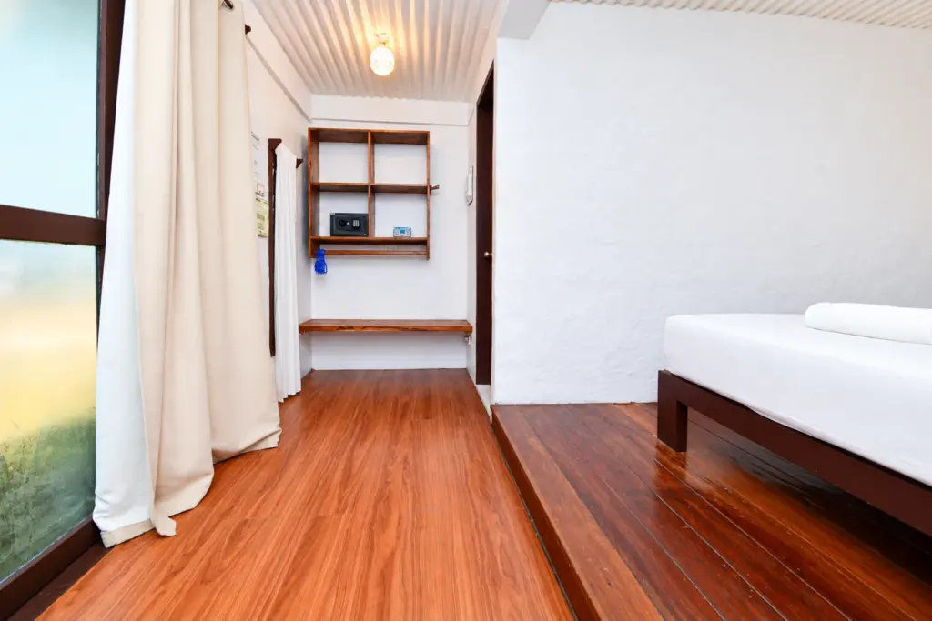 Bed, open shelving and in-room safe near the entrance