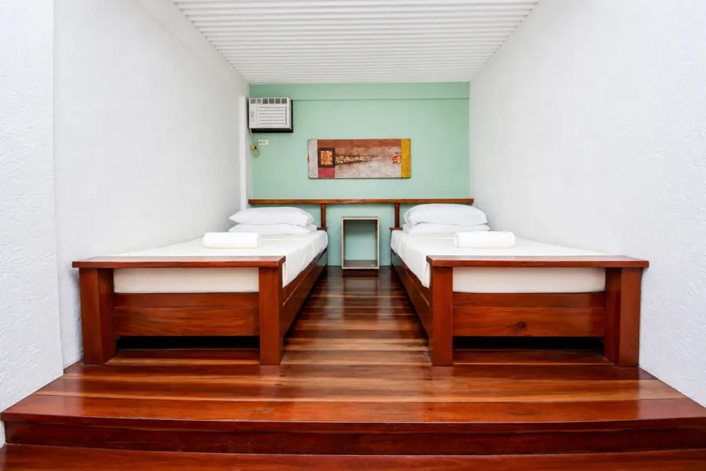 Two single beds against a teal wall with framed artwork