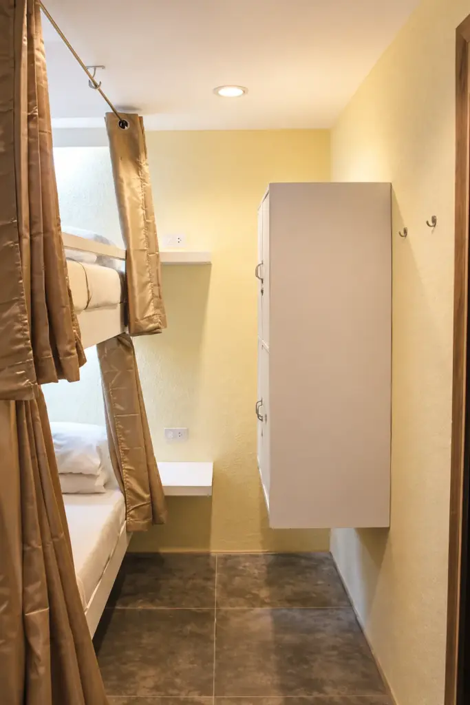 Bunk beds with curtains beside a white locker