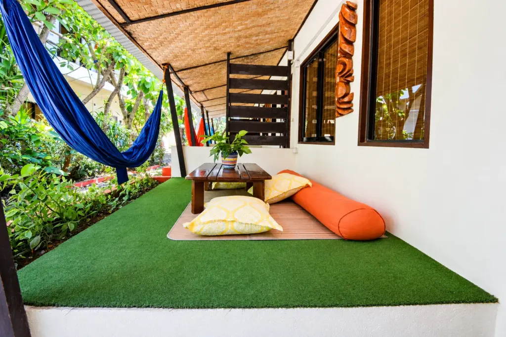 Garden terrace with a blue hammock, floor cushions and a low table