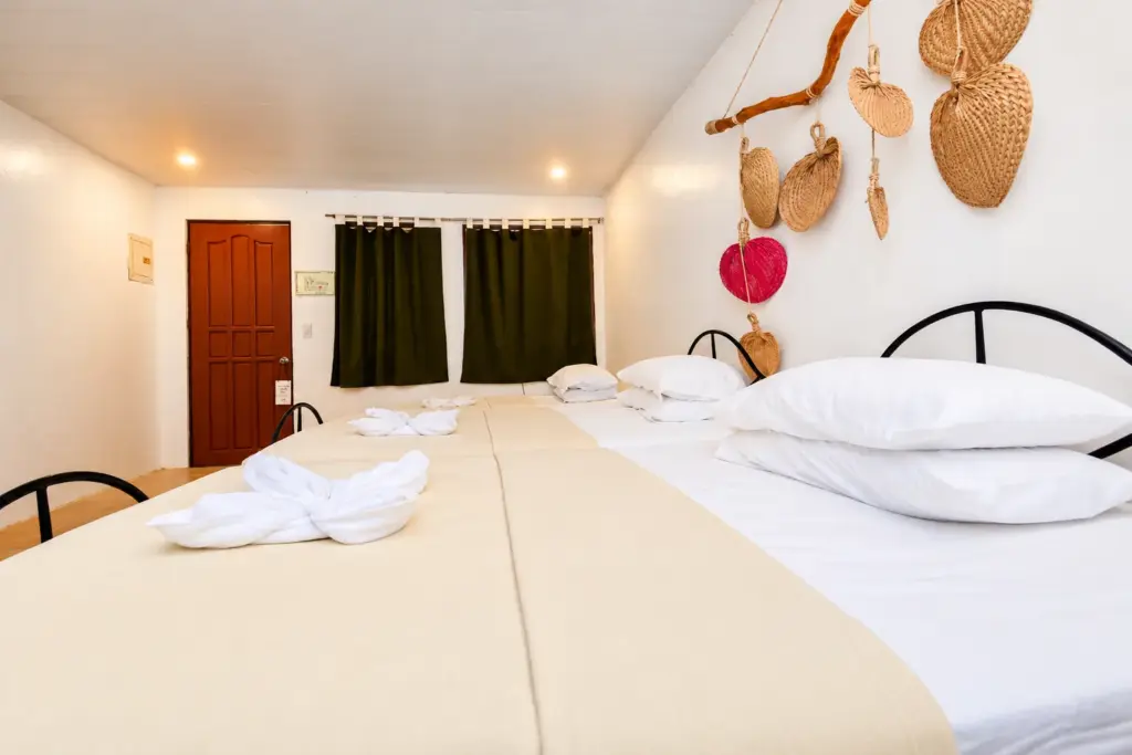 Large bed with plump pillows beside the red door