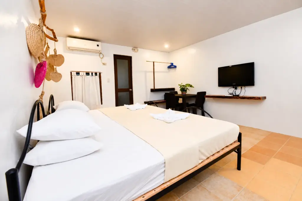 Bed with woven fan decor, with a desk and plant behind