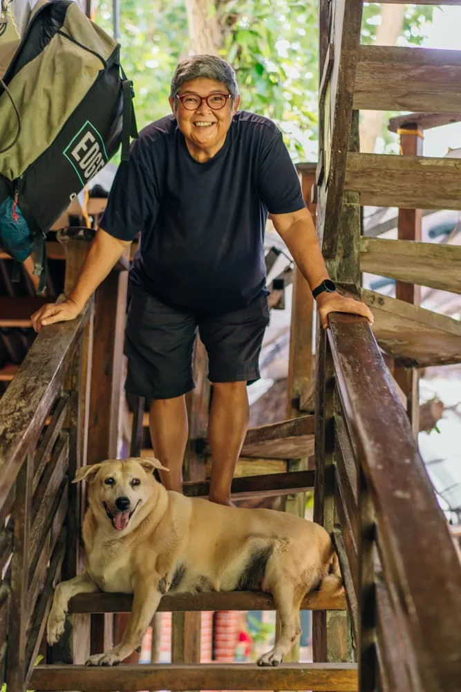 One of the owners on the wooden stairs with a resident dog