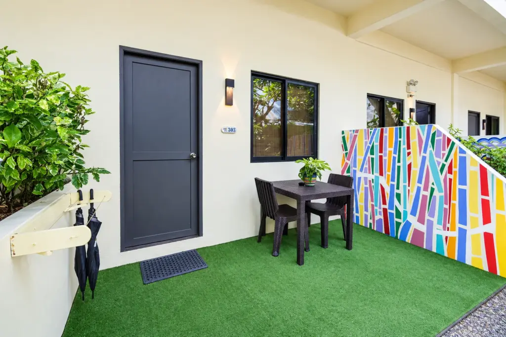 Private terrace outside a Standard Queen with a table, two chairs and a colorful mural wall