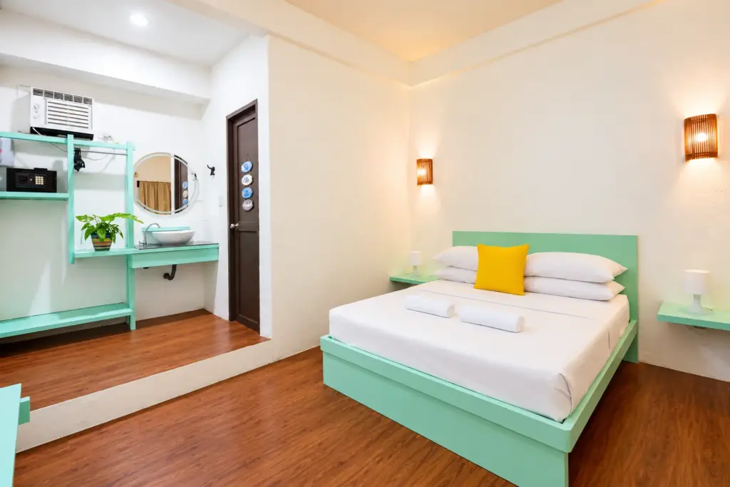 Standard Queen with a mint-green queen bed, wall lamps and a vanity