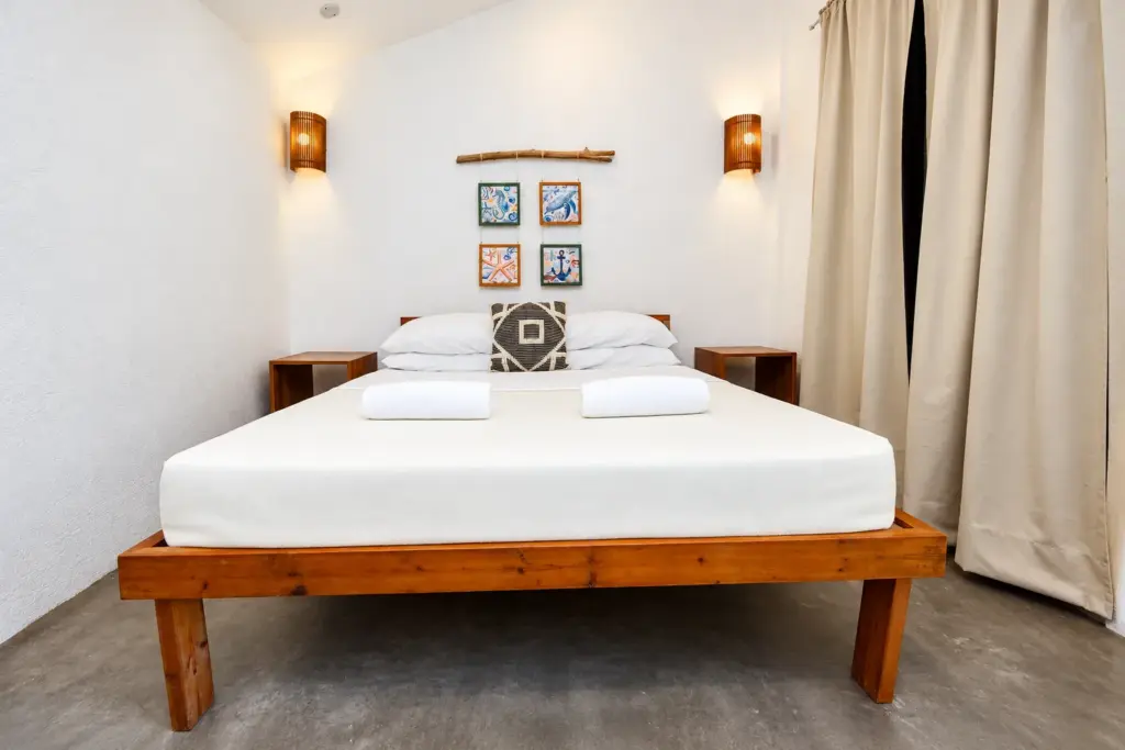 Wooden queen bed with framed artwork and curtains