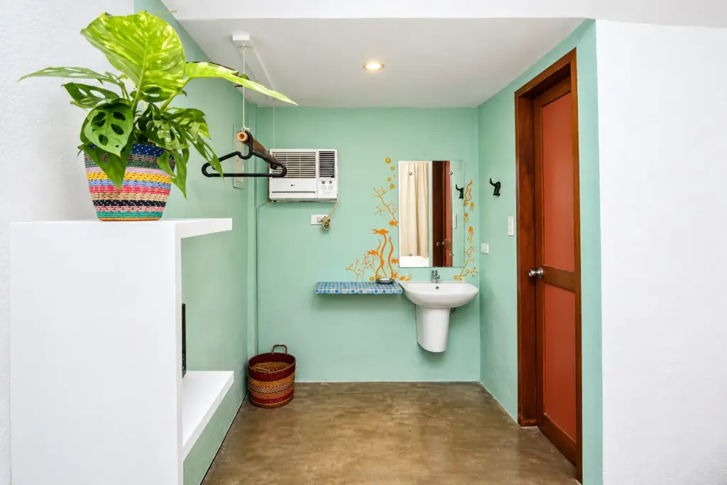 Teal sink nook with a potted plant and woven basket