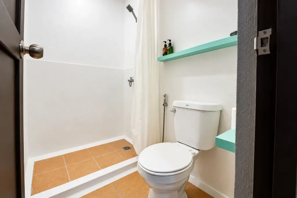 Bathroom with shower, curtain and a mint-green shelf